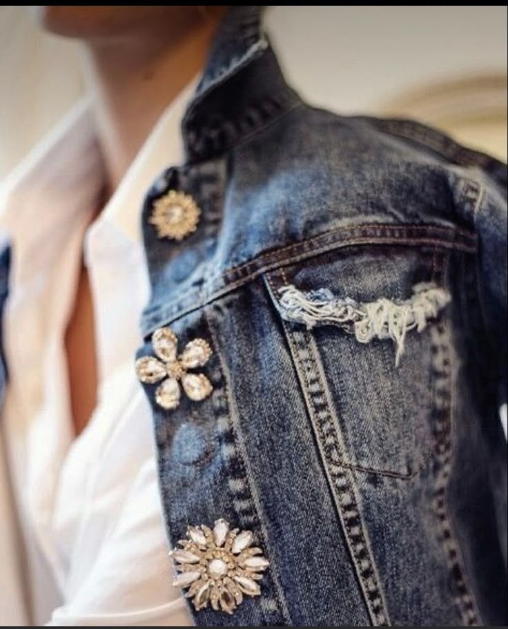 Denim jacket with decorative brooches on a blurred background